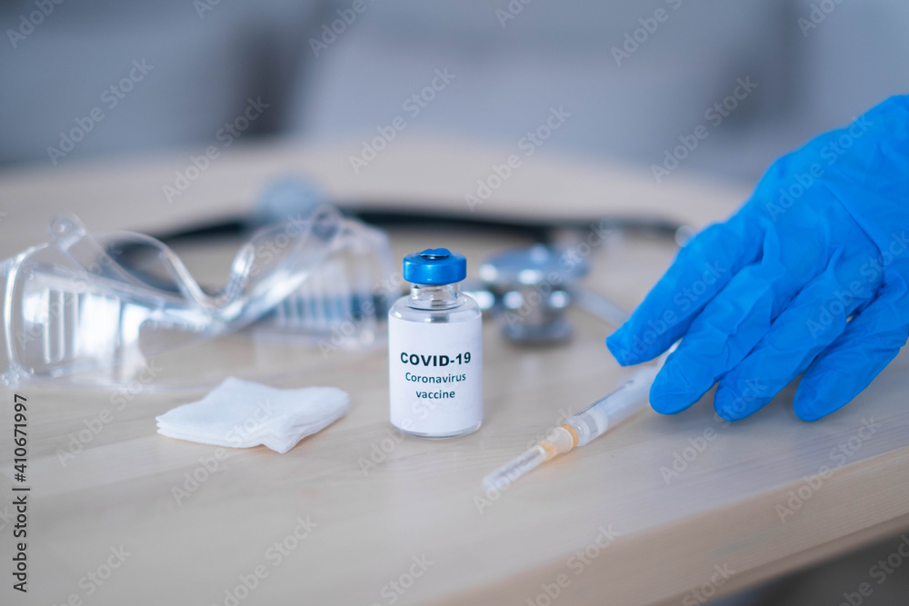 Female doctor with a stethoscope on shoulder holding syringe and COVID-19 vaccine. Healthcare And Medical concept. Female doctor with a stethoscope on shoulder holding syringe and COVID-19 vaccine. Healthcare And Medical concept.
