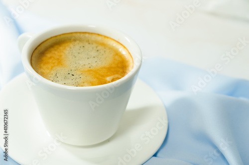  white cup of coffee on blue cloth