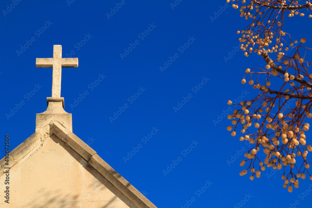 Cemetery stone cross under blue sky