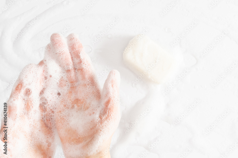 Washing of hands with soap, foam. Cleaning hands. Closeup on woman hands with foam soap bar on white background. Washing of hands with soap, foam. Cleaning hands. Closeup on woman hands with foam soap bar on white background.