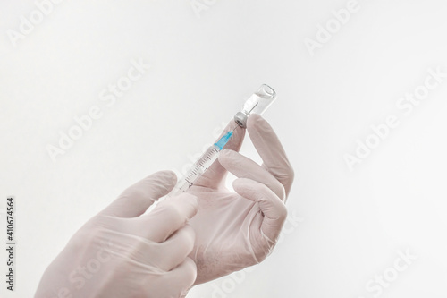 Doctor hands holding a vaccine bottle and syringe,beginning of worldwide mass vaccination for coronavirus COVID-19,influenza or flu,world immunization concept. Selective focus