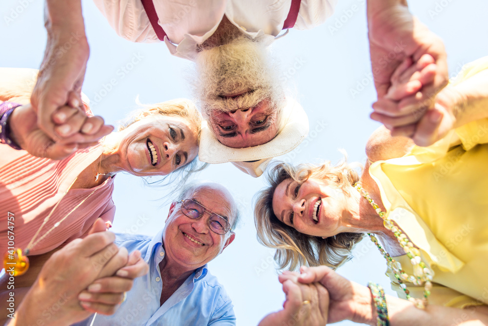 © oneinchpunch - Group of seniors making a picnic at the park and having fun