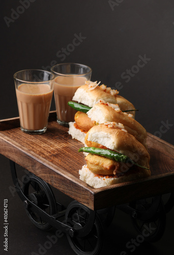 Masala cutting chai and Bombay vada paav is an indian burger. Potato patty is deep fried in gram flour or besan batter it is served hot with paav or bun like sandwich.  photo