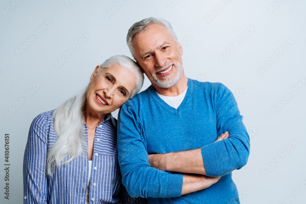 Happy senior couple posing in a studio for a photoshooting Happy senior couple posing in a studio for a photoshooting