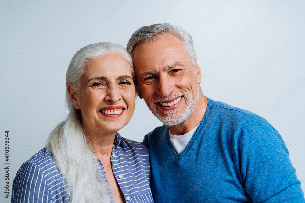 Happy senior couple posing in a studio for a photoshooting Happy senior couple posing in a studio for a photoshooting