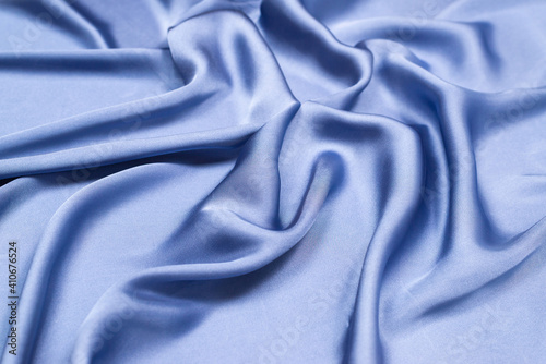 Blue silk or satin luxury fabric texture. Top view.