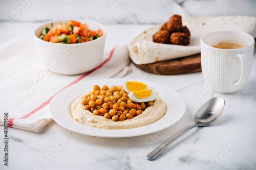 Hummus with boiled chickpeas  egg  falafel  lavash and salad and coffee. Breakfast. Middle Eastern dish