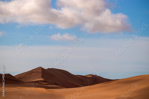 Golden sand dune 7 and white clouds on a sunny day in the Namib desert. Fantastic place for travelers and photographers