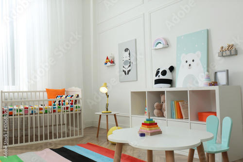 Cute baby room interior with stylish furniture and toys
