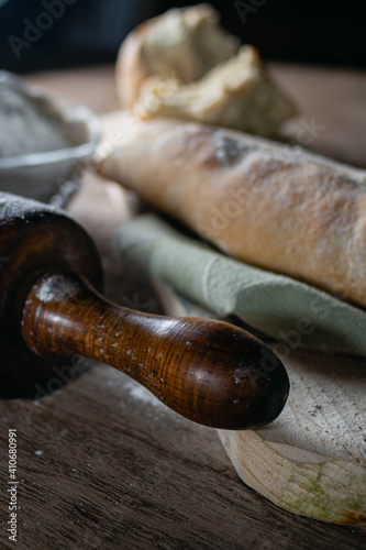 close-up of rolling pin for rolling and flattening dough flour freshly made hot homemade bread on wooden base cordoba argentina