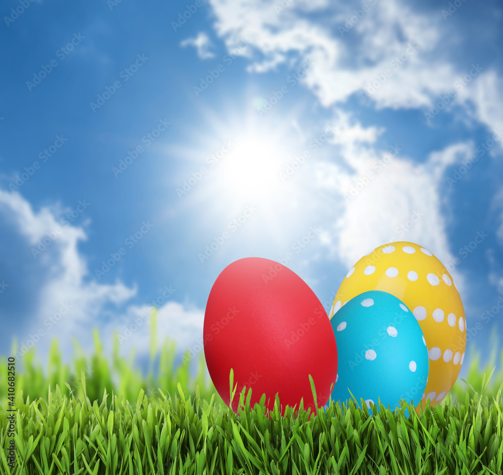 Bright Easter eggs on green grass outdoors, space for text