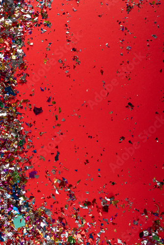 colorful falling confetti on red background.