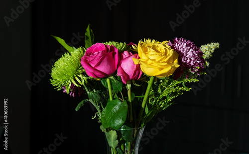 Valentine flower bouquet with ecuadorian yellow and fuchsia roses and chrysanthemums with black background.