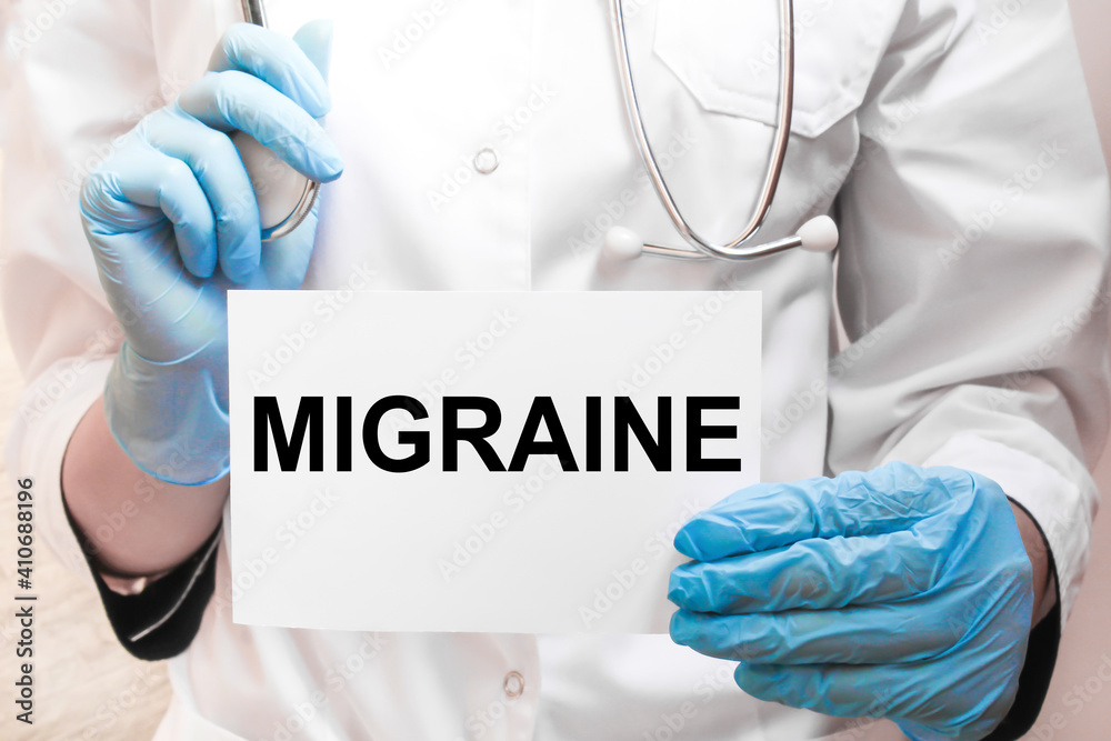 The doctor's blue - gloved hands show the word MIGRAINE - . a gloved hand on a white background. Medical concept. the medicine The doctor's blue - gloved hands show the word MIGRAINE - . a gloved hand on a white background. Medical concept. the medicine