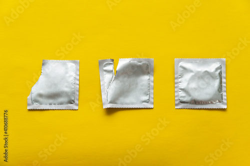 condom and two blank packages on yellow background photo