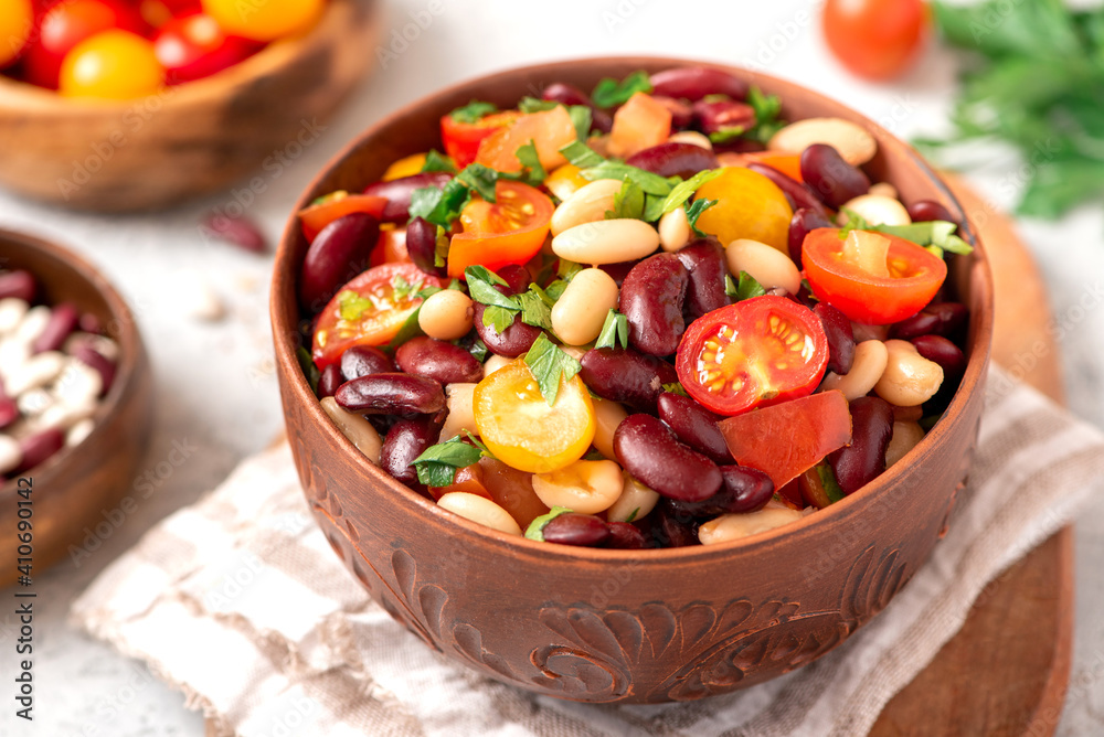 Salad of white and red beans, tomatoes and herbs in a ceramic bowl close-up. Tasty vegan food Salad of white and red beans, tomatoes and herbs in a ceramic bowl close-up. Tasty vegan food