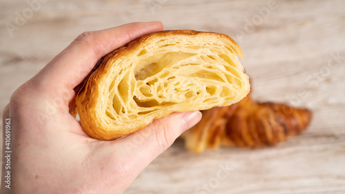 The honeycomb structure of the croissant. Hand holding Classic and buttery French Croissants