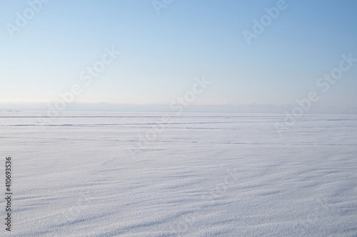 Winter landscape with snow-covered sea and blue sky with clear air.