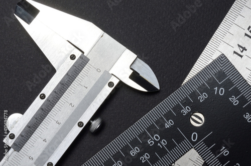 measuring tool, ruler square and caliper. lie on a dark background. close-up.