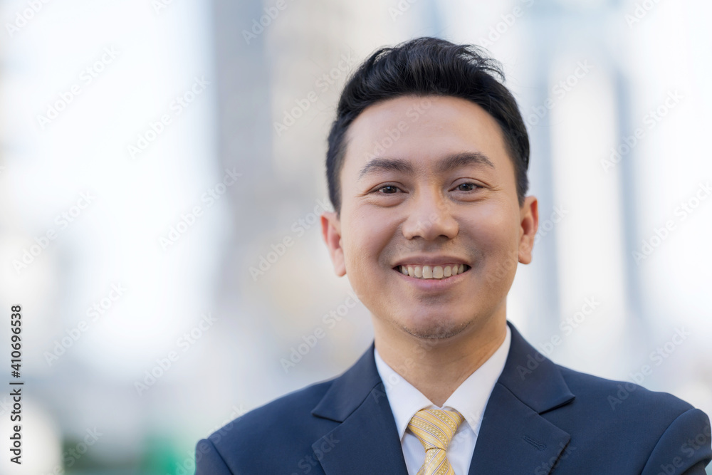 Close up of Smiling businessman standing in front of modern office Close up of Smiling businessman standing in front of modern office