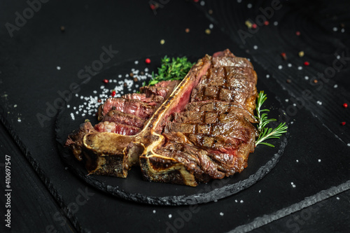 T-bone or aged wagyu porterhouse grilled beef steak with spices and herbs. Gourmet grilled and sliced porterhouse steak. Food recipe background. Close up