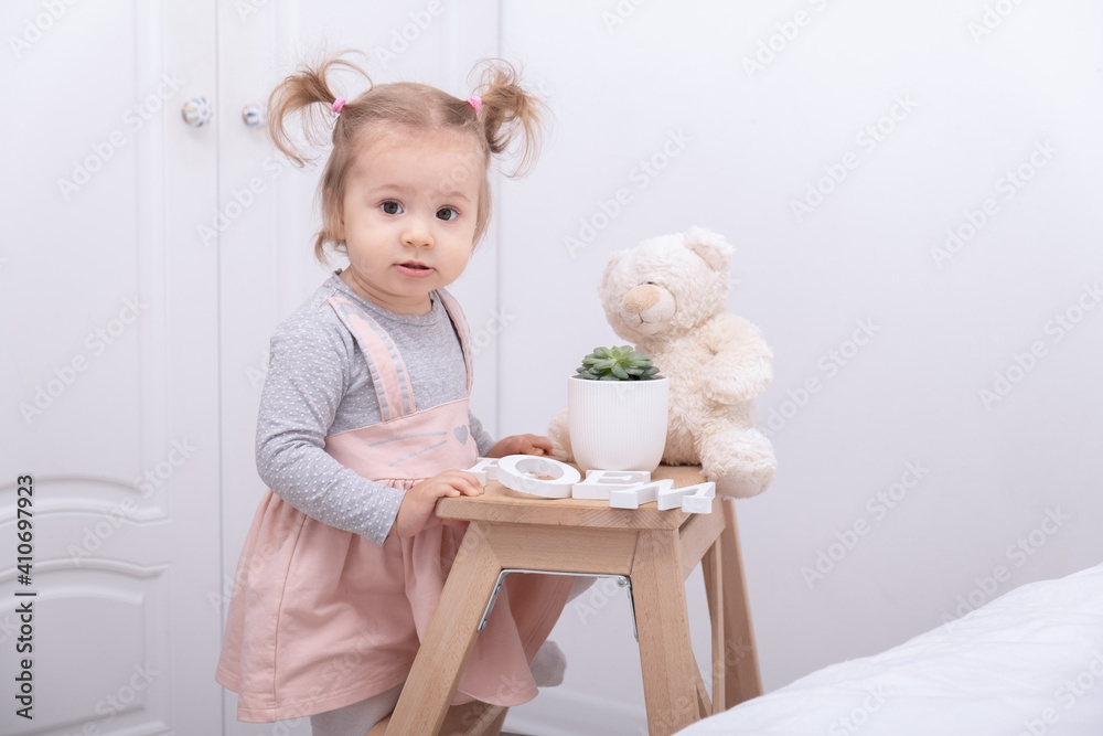funny toddler girl playing with toys at home in white room funny toddler girl playing with toys at home in white room