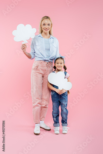 full length of happy mother and daughter holding thought bubbles on pink © LIGHTFIELD STUDIOS