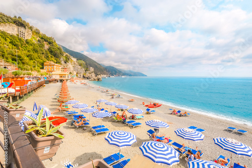 Fototapeta Naklejka Na Ścianę i Meble -  The sea and sandy beach Spiaggia di Fegina at the Cinque Terre Italy resort village of Monterosso al Mare with tourists enjoying the Italian Riviera