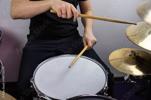 Professional drum set closeup. Man drummer with drumsticks playing drums and cymbals, on the live music rock concert or in recording studio  