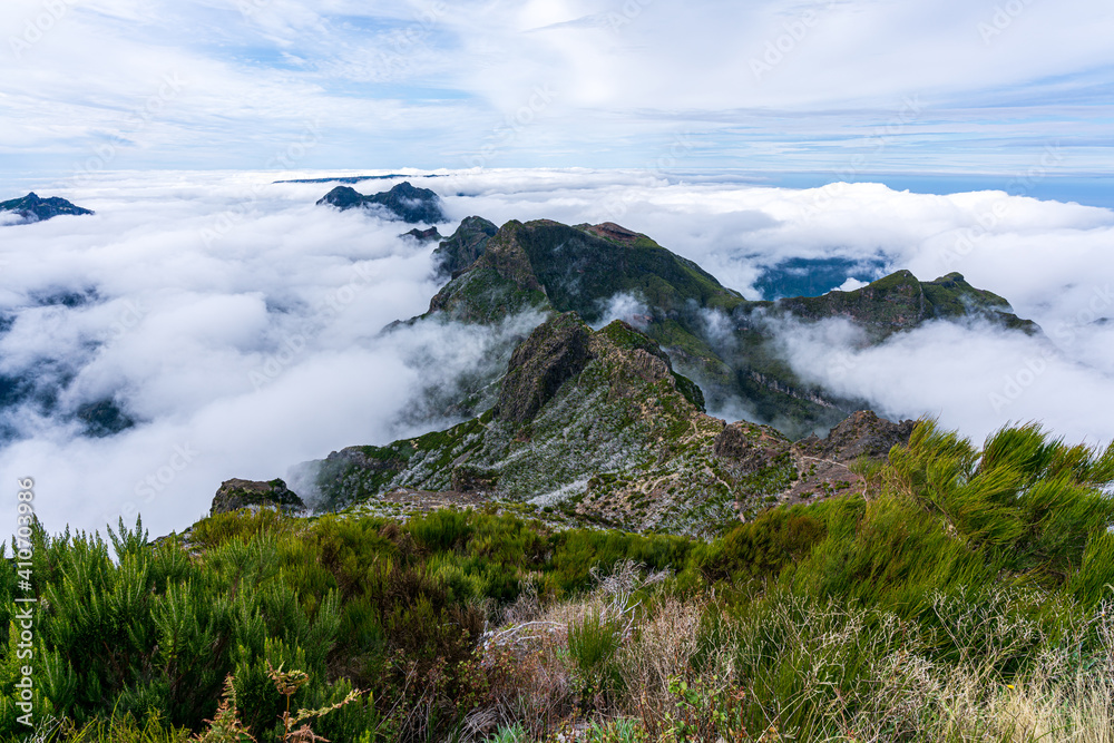 Fototapeta premium Above the clouds on the mountain peak Pico Ruivo towards the opposite peak Achada do Teixeira on Madeira Island - Cloud Covered Mountain Landscape