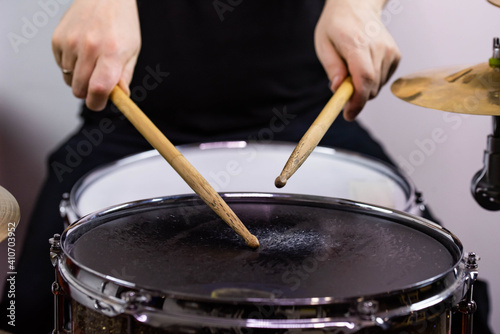 Professional drum set closeup. Man drummer with drumsticks playing drums and cymbals  on the live music rock concert or in recording studio    