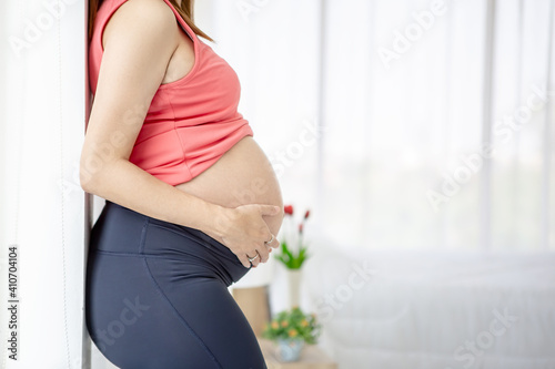 Free Download Pregnant woman taking care of her child by holding baby in her pregnant belly in the bedroom - GFXLoad