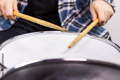 Professional drum set closeup. Man drummer with drumsticks playing drums and cymbals, on the live music rock concert or in recording studio  