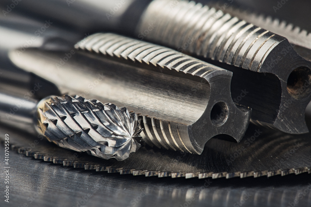 set of different drill bits,thread tap and mill cutters with caliper ruler on steel plate background. Locksmithing deal. set of different drill bits,thread tap and mill cutters with caliper ruler on steel plate background. Locksmithing deal.