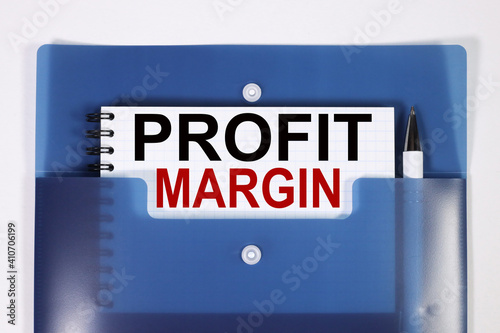 profit margin, text, word, on white paper on a blue folder.