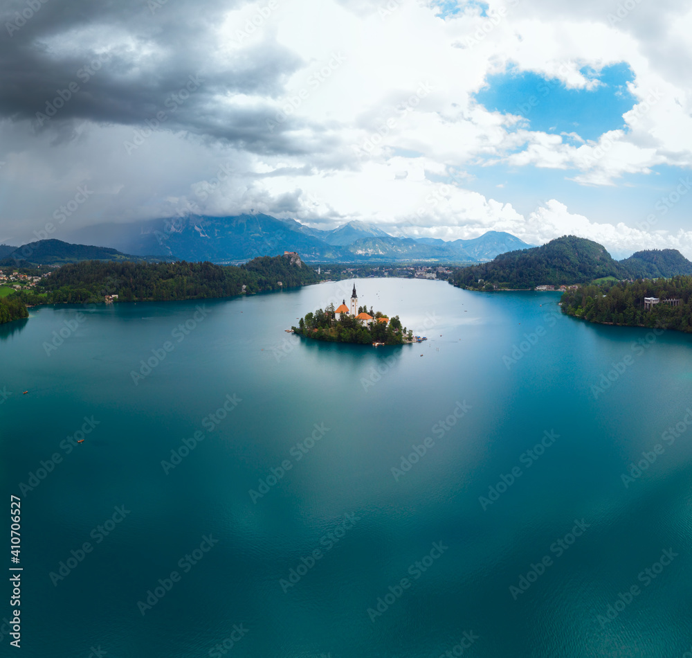 Aerial Square format panoramic view of Lake Bled. Cloudy weather, heavy thunderstorm clouds on the horizon. Summer day. Season of tour and travel. Church of the Mother of God, Slovenia, Europe