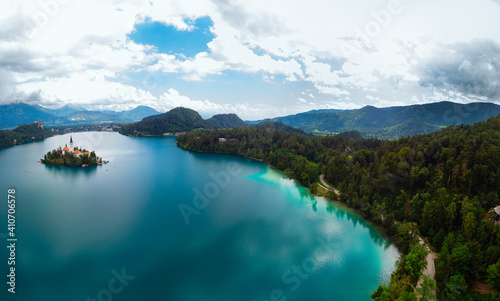 Aerial large wide panoramic view of Lake Bled. Cloudy weather, heavy thunderstorm clouds on the horizon. Summer day. Season of tour and travel. Church of the Mother of God, Slovenia, Europe
