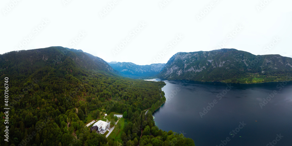 Aerial wide view of the Bohinj lake. Travel and tours concept. Beautiful landscape ot the Triglav mountains, national park, summer forest and the church, Slovenia, Europe