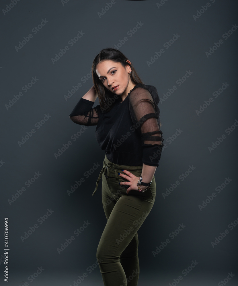 Portrait of beautiful model in black dress, hat and sunglasses on gray background Portrait of beautiful model in black dress, hat and sunglasses on gray background