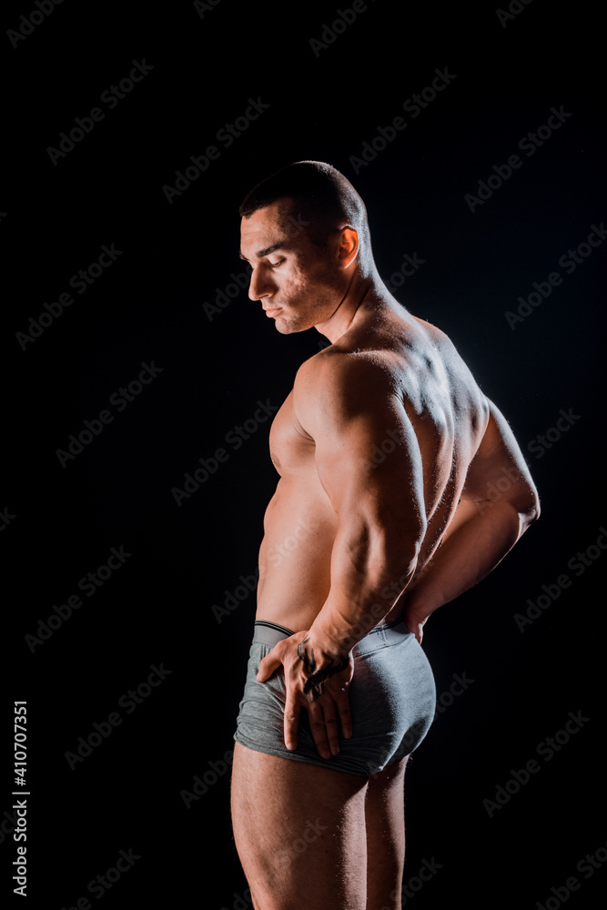 Young bodybuider with tattoos posing in studio Young bodybuider with tattoos posing in studio