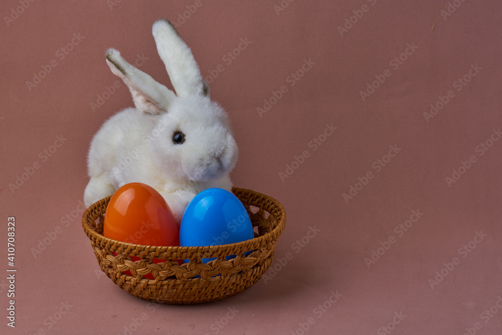 Little white rabbit in the surround with different color of ester eggs. Little white rabbit in the surround with different color of ester eggs.