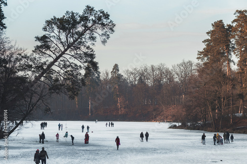 people walking on a frozen lake on a winter evening