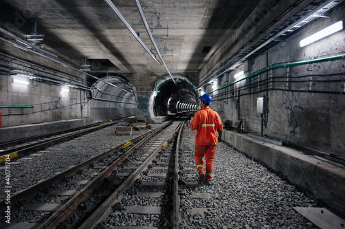 Photo worker walking at railway tunnel