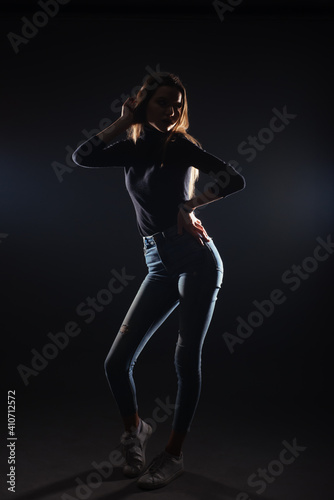 Silhouette picture of a young gorgeous woman posing on black background © qunica.com