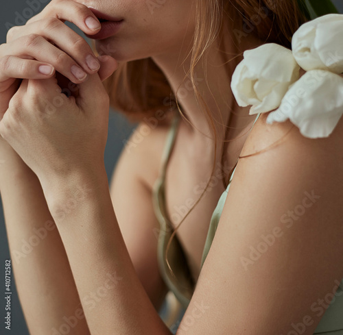 Woman's hands touches chin and lips emotions thinking closeup flowers tulips