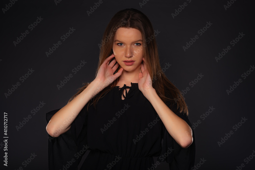 Close up portrait of a sexy female model looking serious while posing in black clothes inside a studio Close up portrait of a sexy female model looking serious while posing in black clothes inside a studio