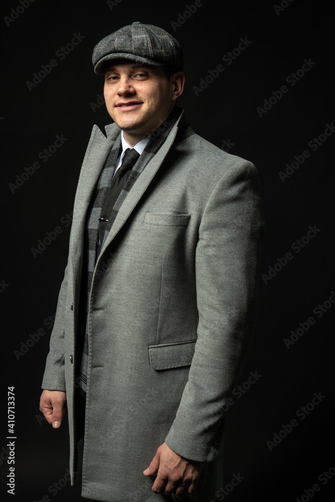 in a coat and a cap Young male three piece suit business businessman man, young salesman model, elegance background black bodybuilder