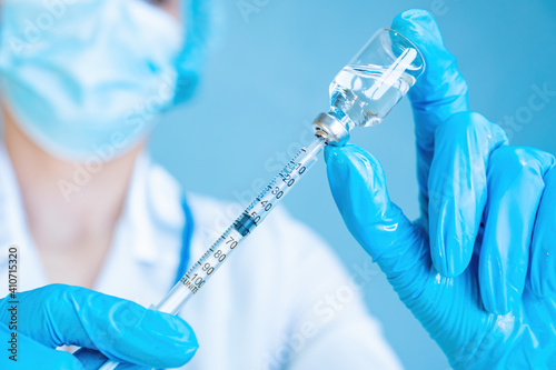 A female doctor draws medicine from a medicine bottle into an insulin syringe. Treatment of diabetes mellitus with insulin dependence. Vaccination against COVID-19. Medical services advertising banner
