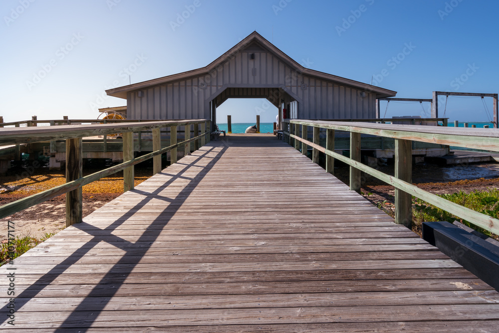 Obraz premium Ocean pier with a wooden walk in front in tropical paradise on a sunny day. Dry Tortugas, Florida.