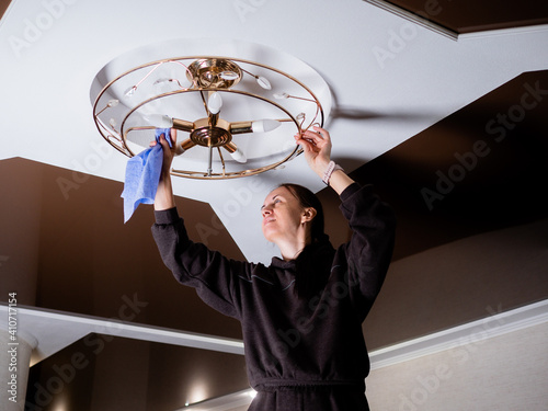 House cleaning, close-up of hands with rag detergent, cleaning and polishing lamp, chandelier